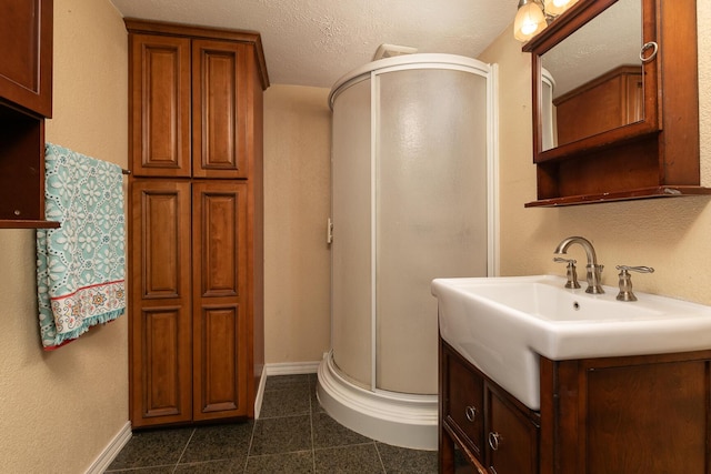 bathroom with vanity, an enclosed shower, tile patterned flooring, and a textured ceiling