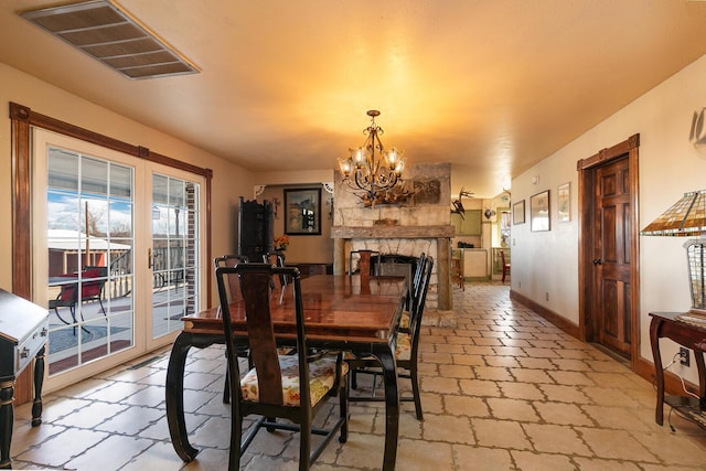 dining room with a notable chandelier and a fireplace