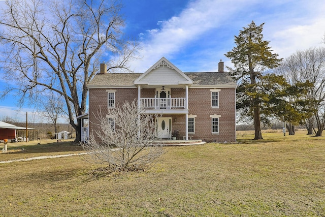 view of front of property with a balcony and a front yard