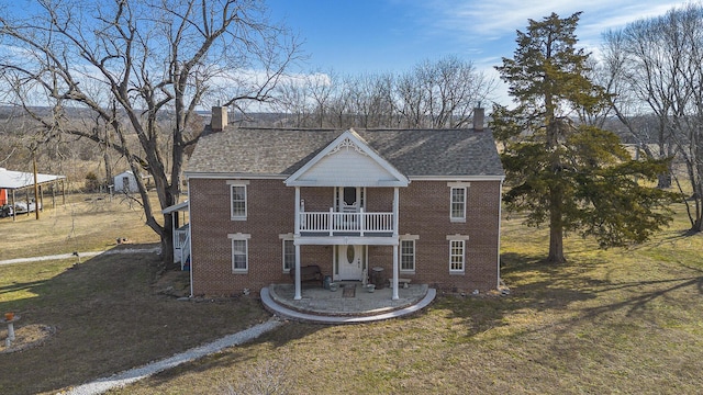 view of front of home featuring a front lawn, a patio, and a balcony