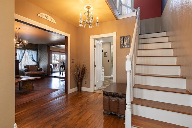 entryway with dark wood-type flooring and a chandelier