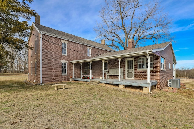 view of front of house with a front lawn, central air condition unit, and covered porch