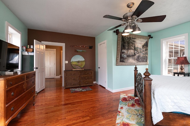 bedroom with dark hardwood / wood-style flooring and ceiling fan