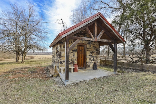 view of outdoor structure with a rural view and a yard