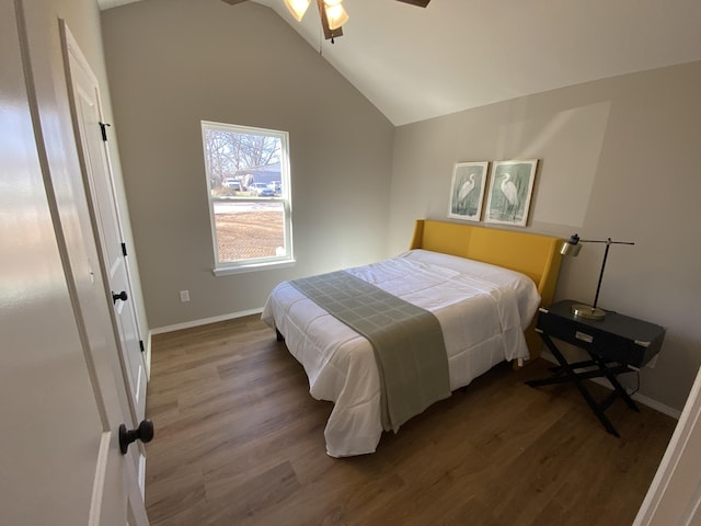 bedroom featuring lofted ceiling, wood finished floors, and baseboards