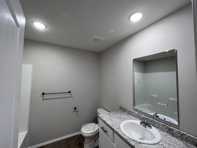 full bathroom with vanity, hardwood / wood-style flooring, shower / tub combination, and toilet