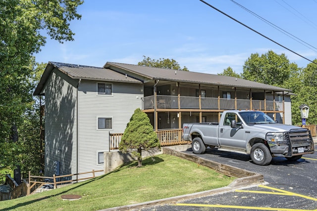 view of front of house with a front yard and a balcony