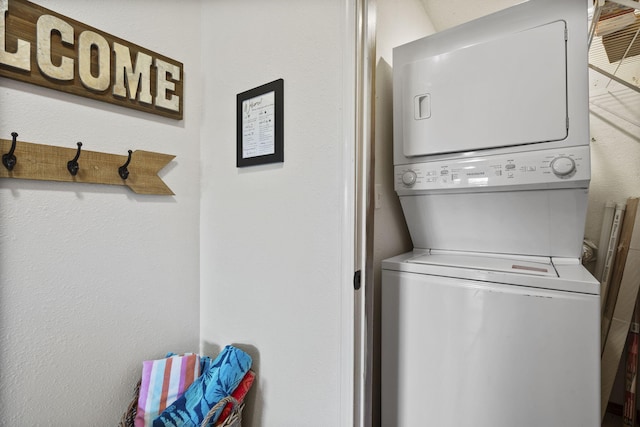 clothes washing area featuring stacked washer and clothes dryer