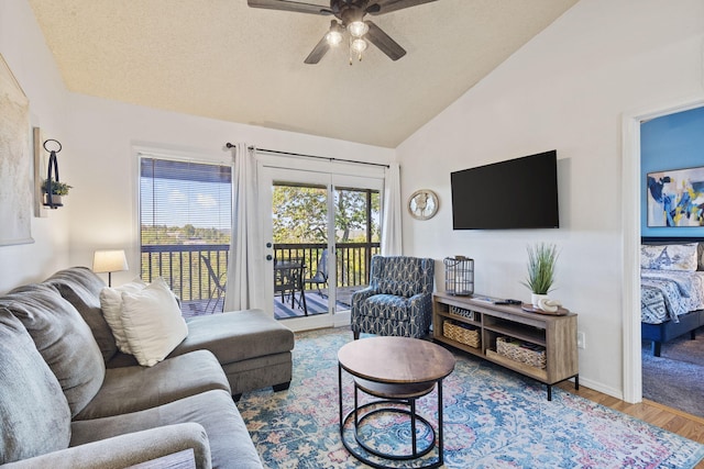 living room featuring ceiling fan, lofted ceiling, and wood-type flooring