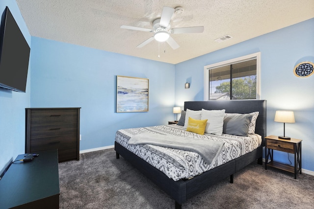 bedroom with ceiling fan, dark carpet, and a textured ceiling