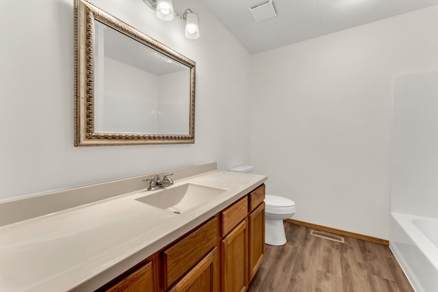 bathroom featuring wood-type flooring, toilet, and vanity