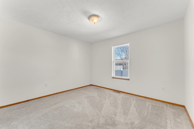 carpeted empty room with a textured ceiling