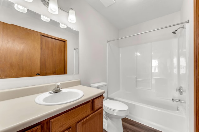 full bathroom with hardwood / wood-style flooring, shower / bathtub combination, vanity, and toilet