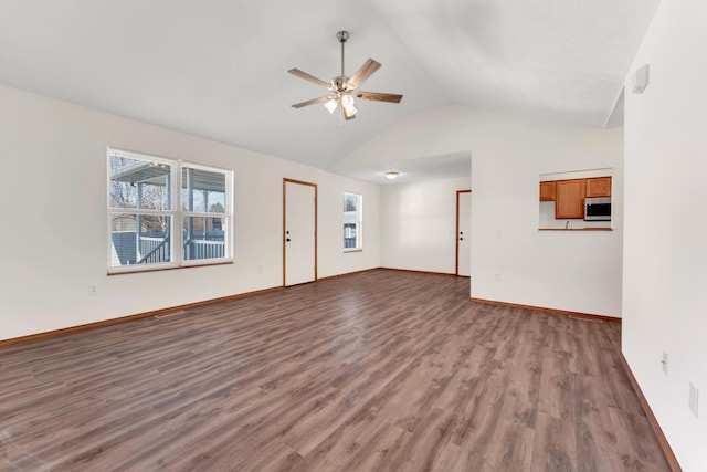 unfurnished living room featuring vaulted ceiling, ceiling fan, hardwood / wood-style floors, and a wealth of natural light