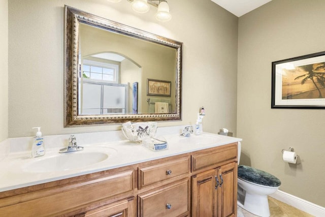 bathroom with tile patterned flooring, vanity, an enclosed shower, and toilet