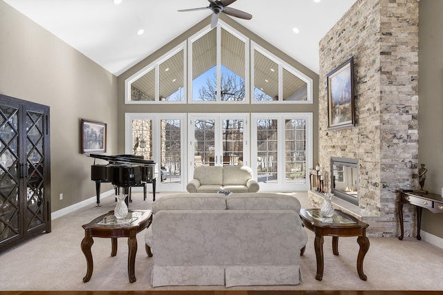 living area featuring carpet flooring, plenty of natural light, a stone fireplace, and high vaulted ceiling