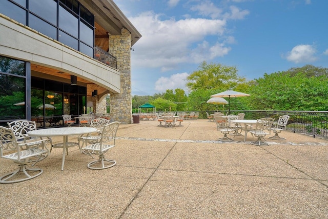 view of patio with a balcony and outdoor dining area