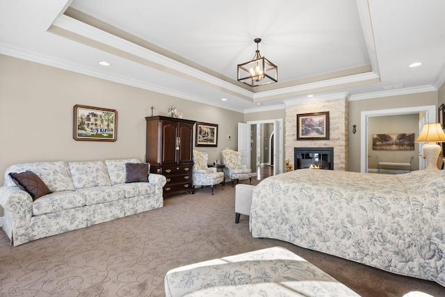 carpeted bedroom featuring a raised ceiling, ornamental molding, a notable chandelier, and a fireplace