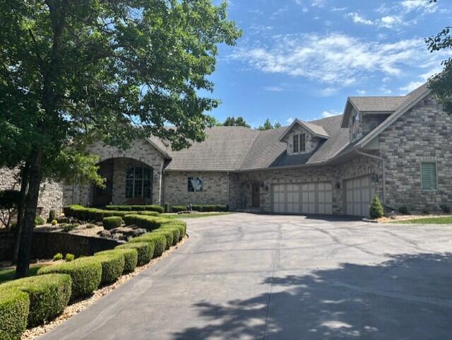 119 Silver Oak Way, Branson West, MO 65737 - view of front facade with stone siding, asphalt driveway, and a garage