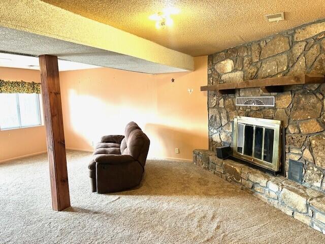 160 Old Glory Rd, Branson, MO 65616 - unfurnished living room featuring a stone fireplace, carpet, and a textured ceiling