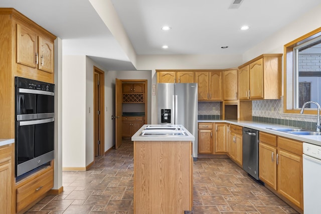 kitchen with stainless steel appliances, a kitchen island, sink, and decorative backsplash