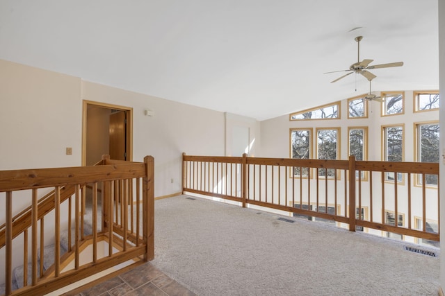 hallway featuring dark carpet, plenty of natural light, and vaulted ceiling