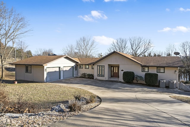 ranch-style home with a garage and central air condition unit