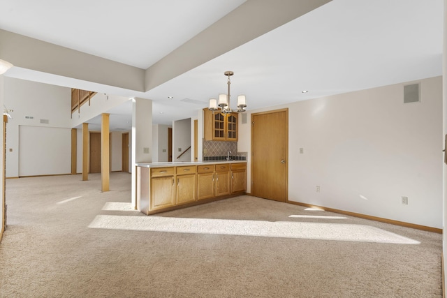 kitchen with a notable chandelier, sink, light carpet, and backsplash