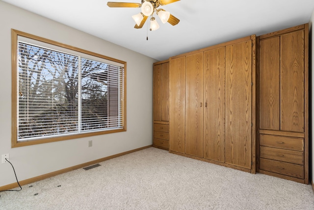 unfurnished bedroom with ceiling fan and light colored carpet