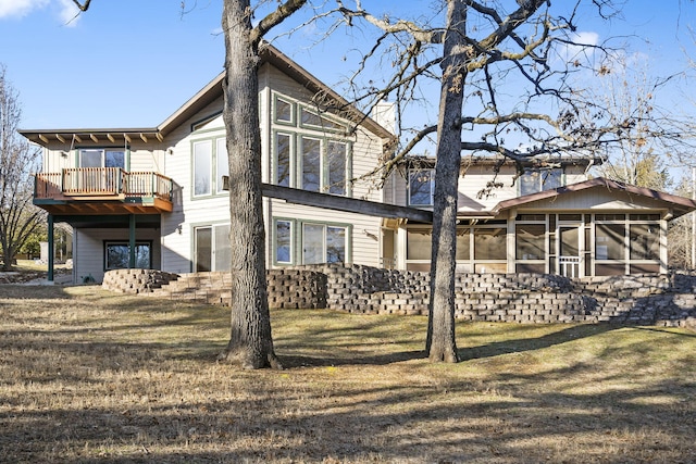 rear view of property with a sunroom and a yard