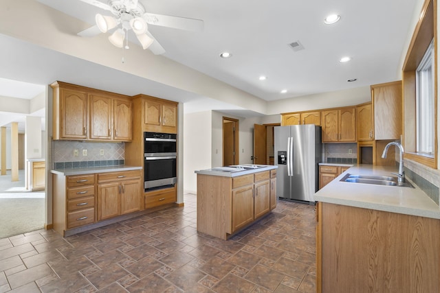 kitchen featuring sink, decorative backsplash, a kitchen island, and appliances with stainless steel finishes