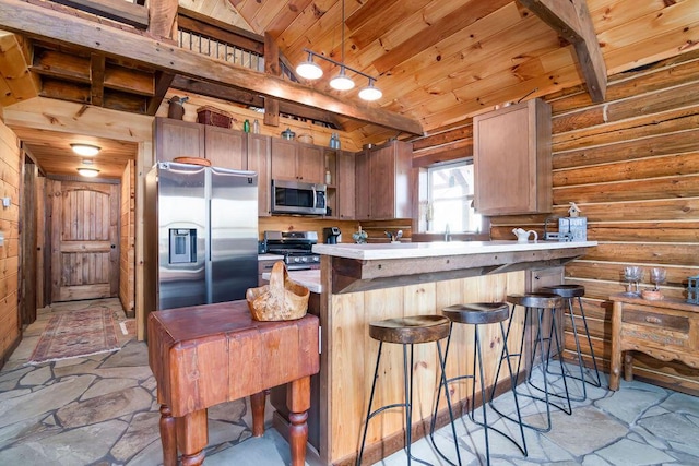 kitchen featuring a breakfast bar area, vaulted ceiling, wooden ceiling, appliances with stainless steel finishes, and kitchen peninsula