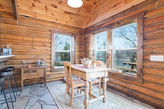 dining room featuring log walls, vaulted ceiling, and wooden ceiling