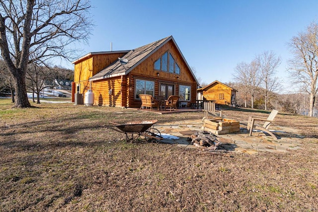 rear view of property featuring a patio area and a fire pit