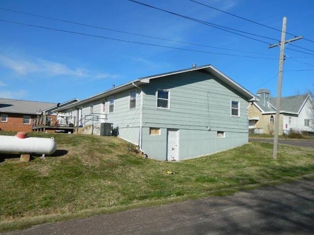 view of property exterior with a lawn and central air condition unit