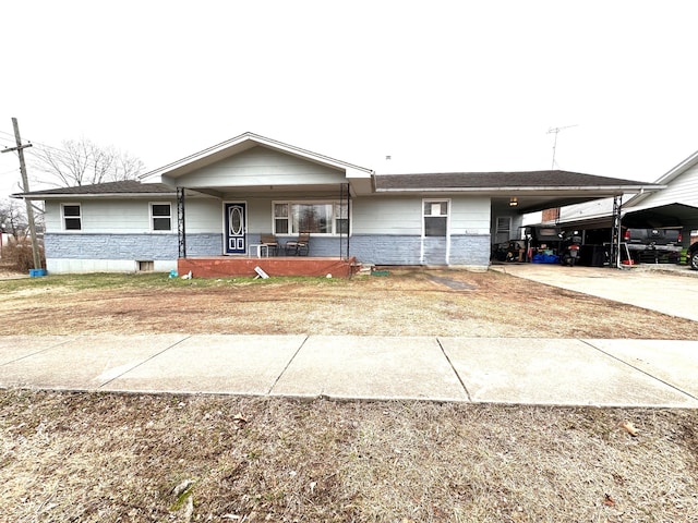 ranch-style house featuring an attached carport, a porch, and concrete driveway