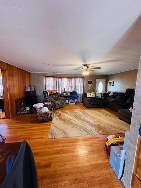 living area featuring plenty of natural light, wood finished floors, and a ceiling fan