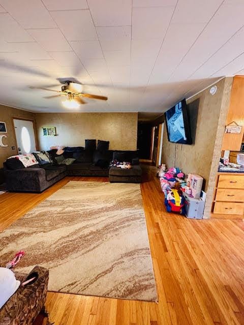 living room with a ceiling fan and wood finished floors