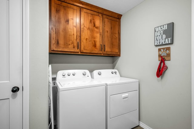 laundry room featuring washer and clothes dryer and cabinets