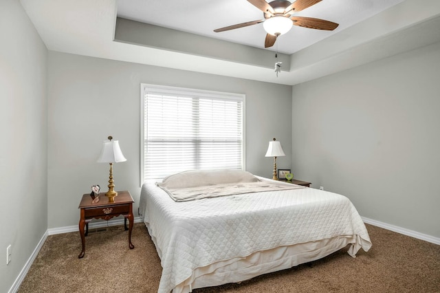 bedroom with carpet floors, a raised ceiling, and ceiling fan