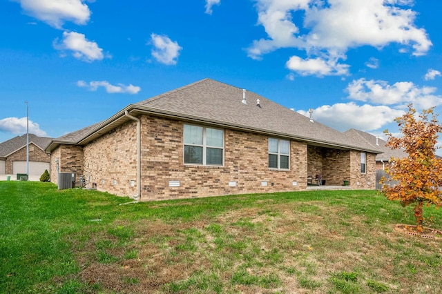 back of house featuring central AC unit and a lawn