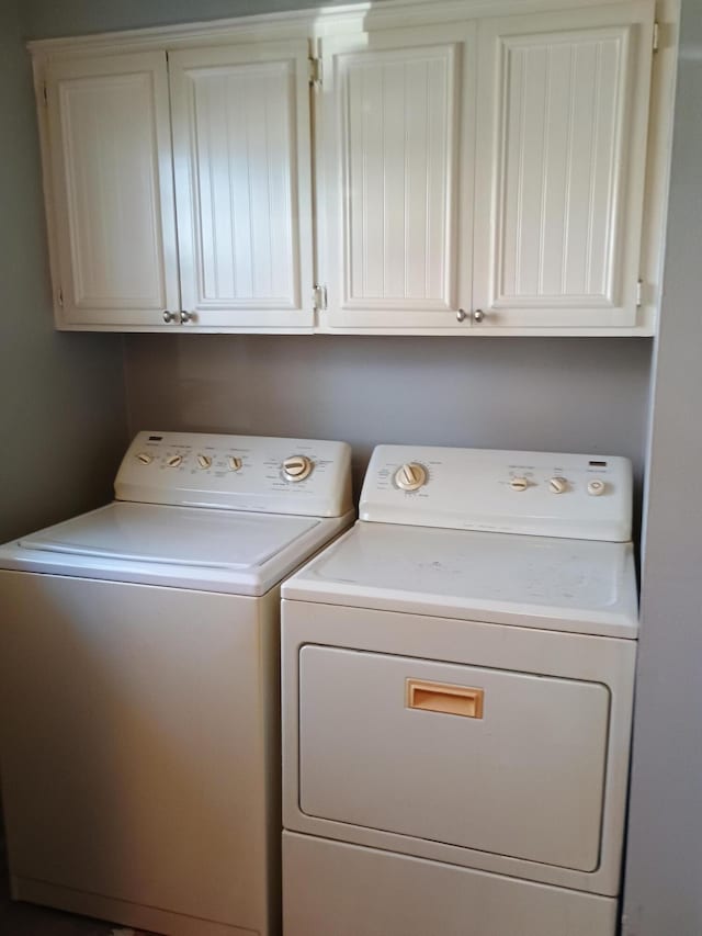 laundry room featuring cabinets and washing machine and clothes dryer