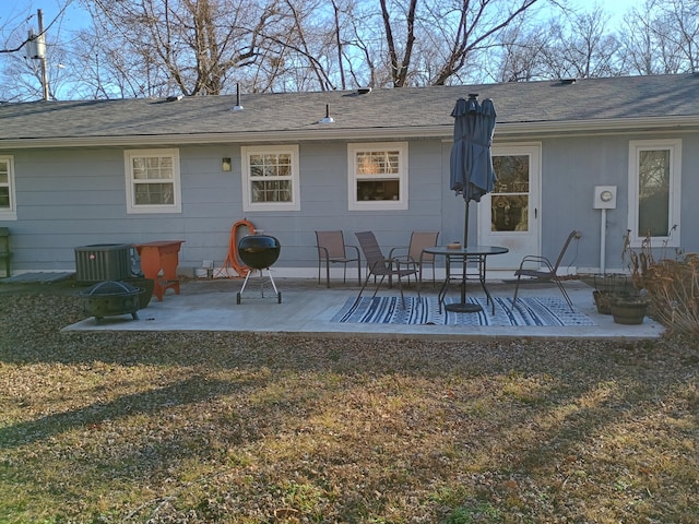 back of house with a yard, an outdoor fire pit, a patio area, and central air condition unit