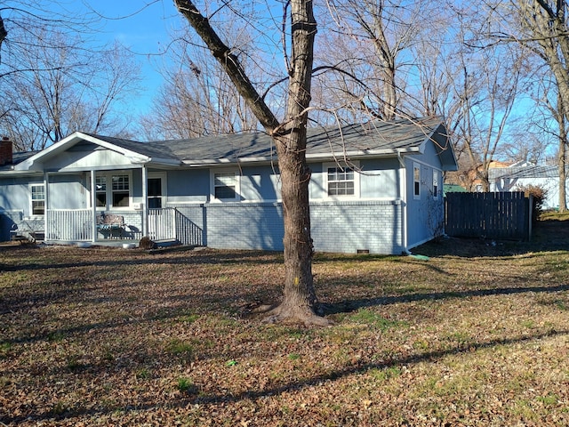 view of side of property with a porch and a yard