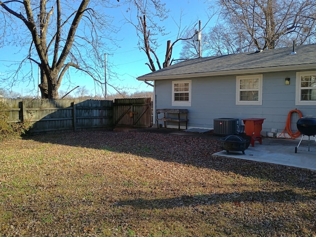 back of property featuring cooling unit, a yard, a patio area, and an outdoor fire pit