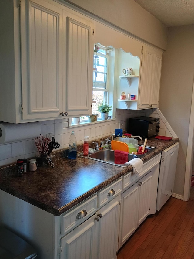 kitchen featuring white cabinetry, wood-type flooring, sink, and tasteful backsplash