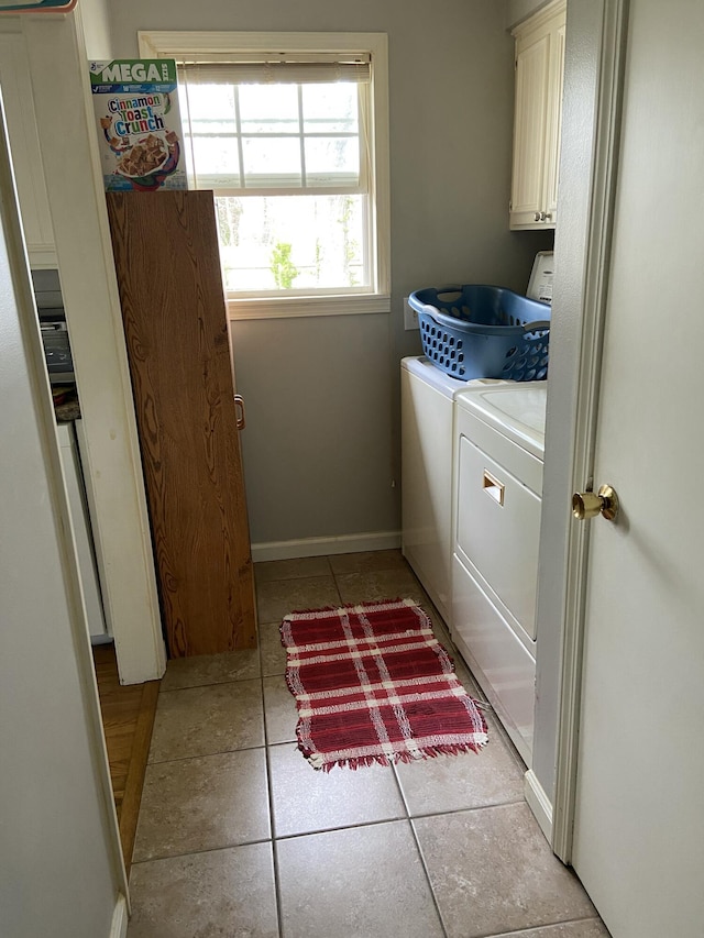 laundry room featuring light tile patterned floors, cabinet space, baseboards, and washer and dryer
