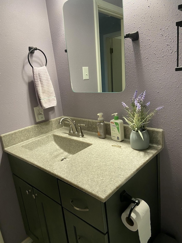 bathroom featuring a textured wall and vanity