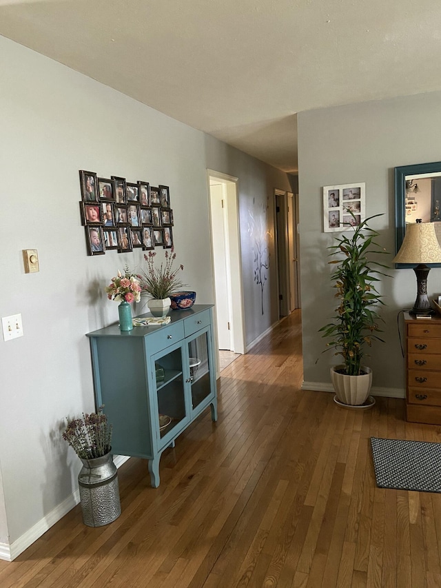 hallway with baseboards and hardwood / wood-style flooring