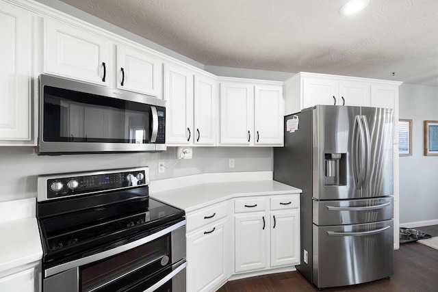 kitchen featuring stainless steel appliances, dark wood-type flooring, white cabinets, and a textured ceiling